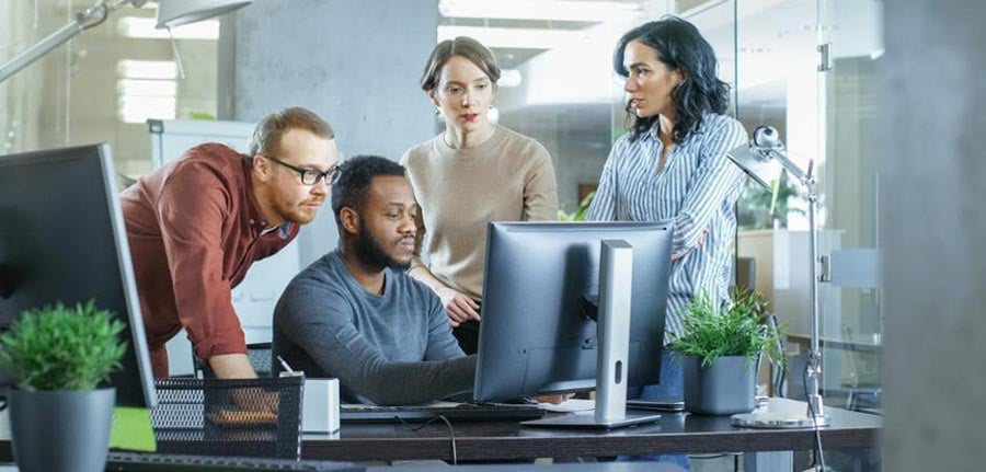 Forbes article business meeting four people looking at a computer